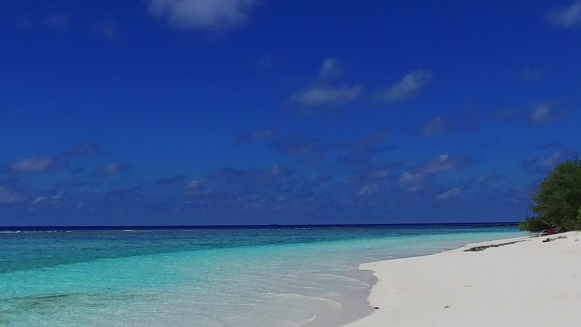 在珊瑚礁附近的蓝海和白沙的背景下近距离欣赏完美的海岸海滩视频的预览图