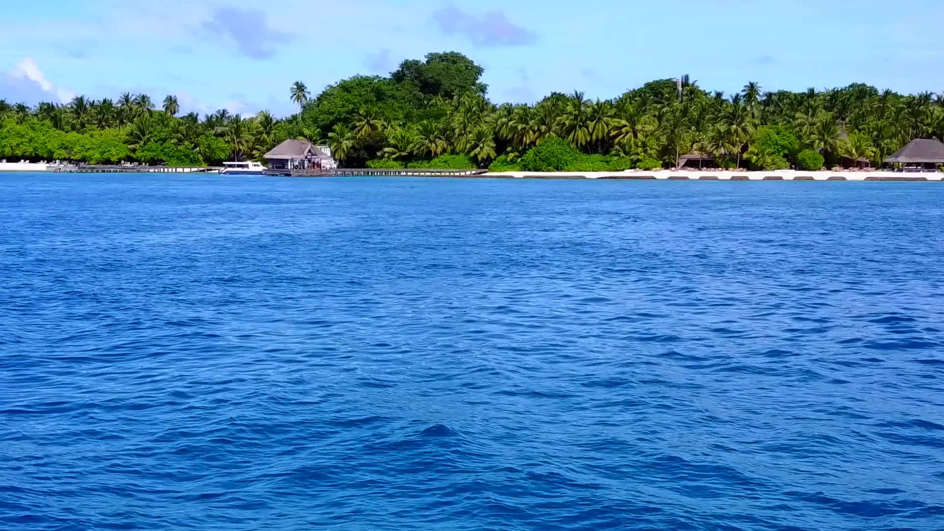 蓝色的海洋在珊瑚礁附近有一个白色的海滩背景视频的预览图