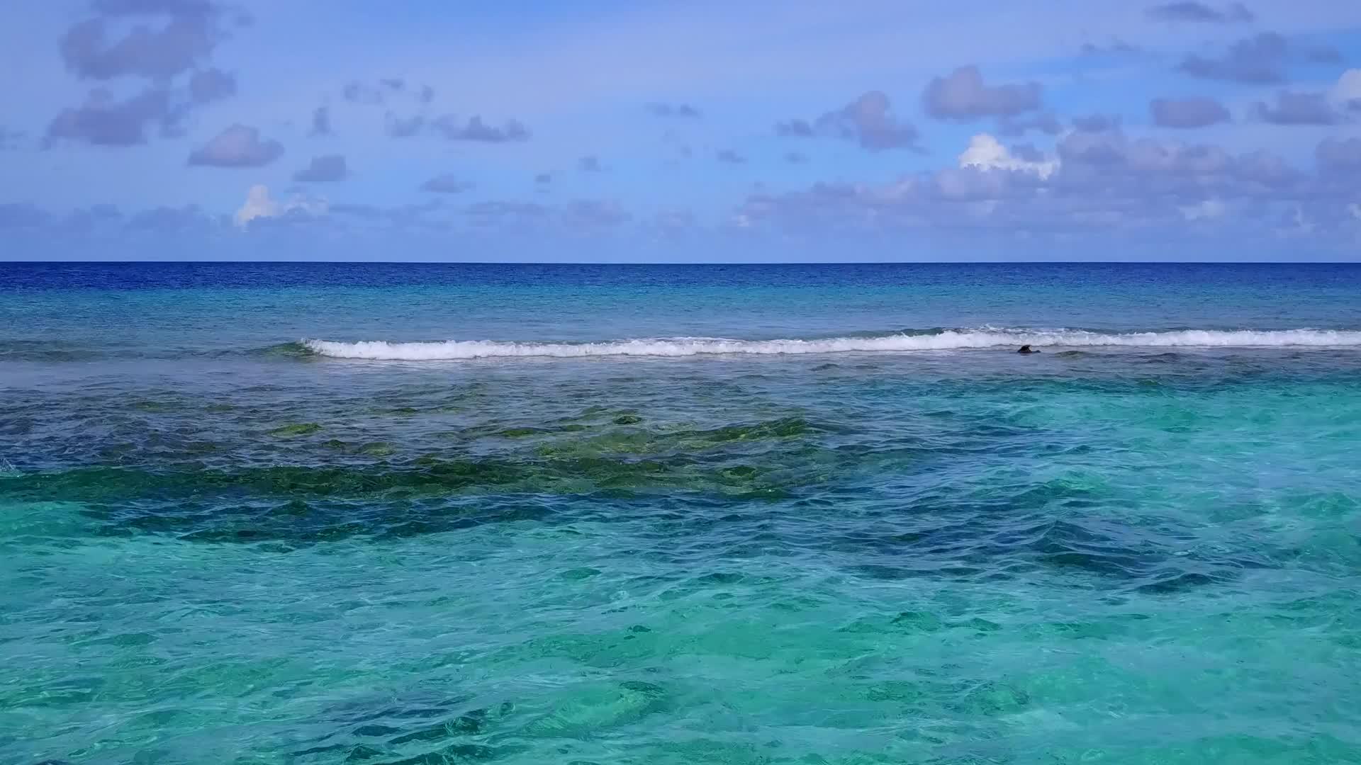 阳光明媚的宁静海岸海滩被绿色的绿色海洋打破了阳光下有白色的沙子视频的预览图