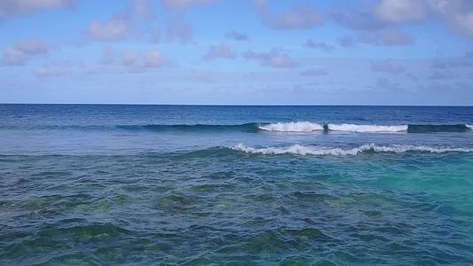 蓝色的海洋和冲浪附近的浅沙背景凉爽的风景平静的旅游海滩视频的预览图