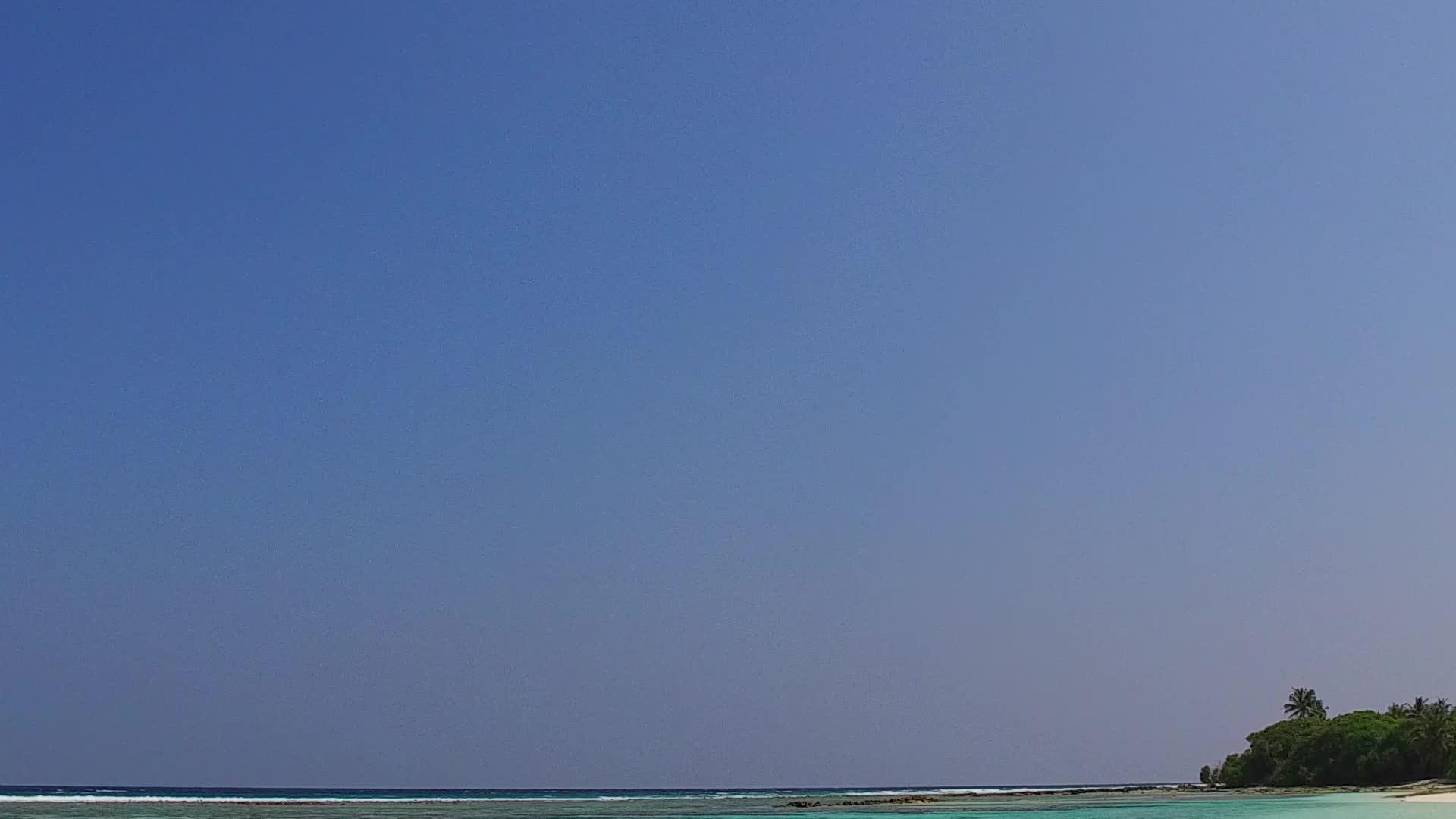 日出后以蓝水和白沙为背景的海滨休闲度假有一个宽阔的角落视频的预览图