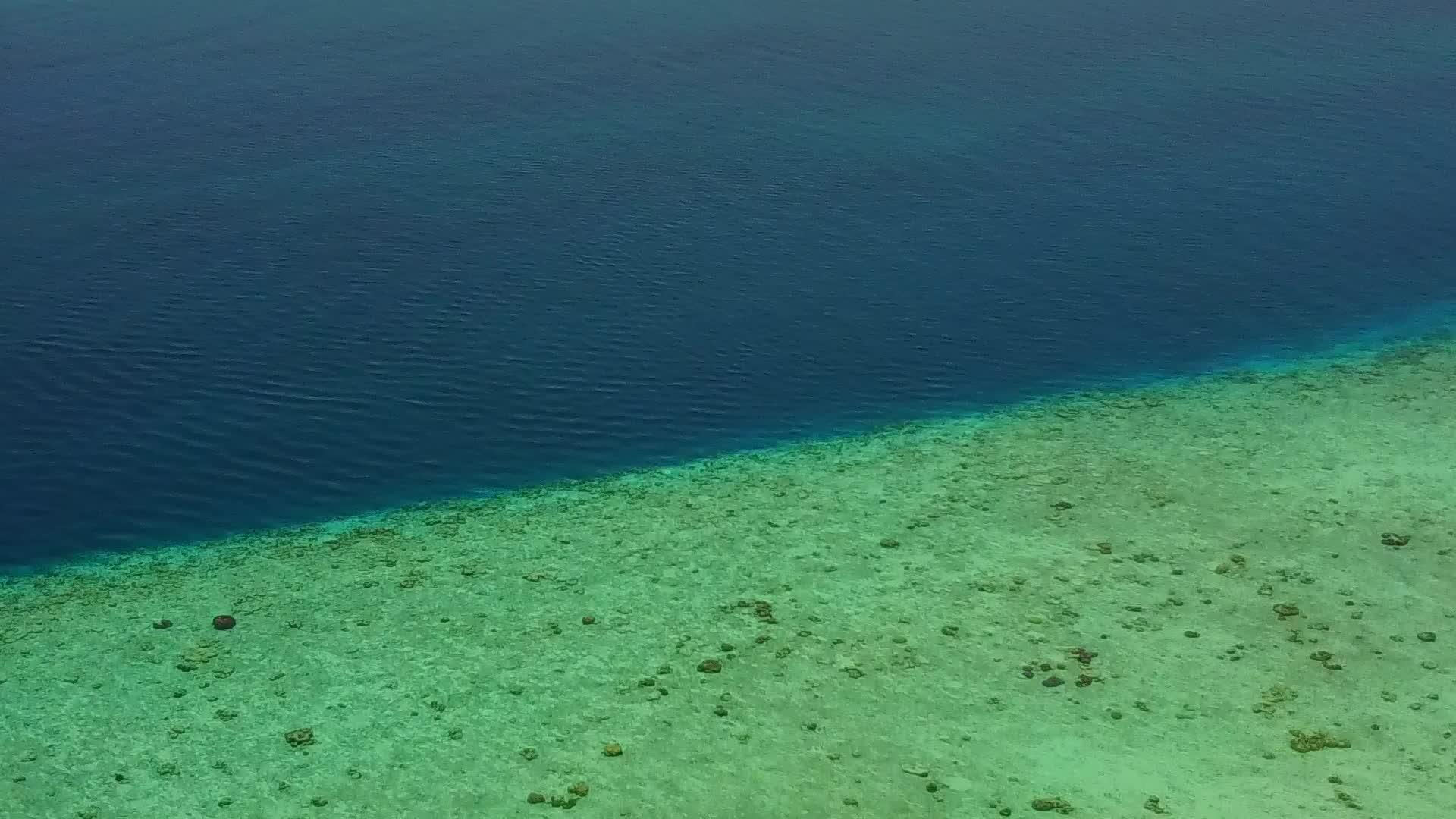 蓝色的水打破了海滩在珊瑚礁附近有白色沙子的背景视频的预览图