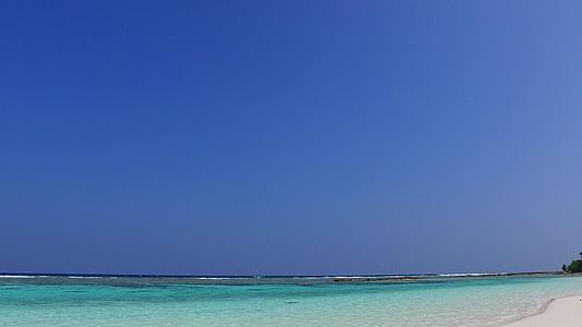 蓝色泻湖热带度假海滩特写镜头靠近棕榈树的白色沙滩背景视频的预览图