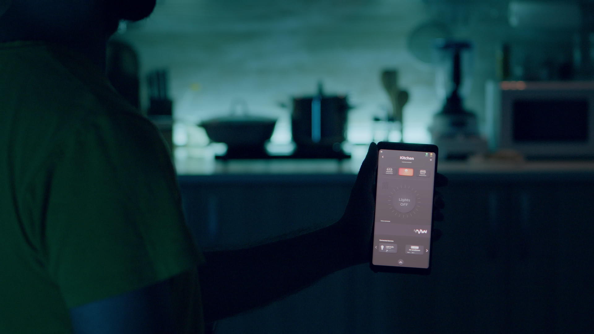 男人在厨房里使用照明控制应用程序手持手机的男人视频的预览图