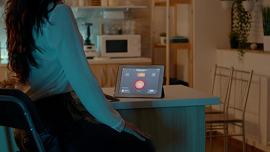 女性用自动照明系统看家里的平板电脑视频的预览图