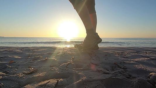 年轻女性在黎明时穿着运动鞋沿着海岸行走视频的预览图