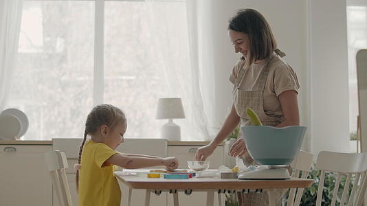 母亲和小女儿在厨房里视频的预览图