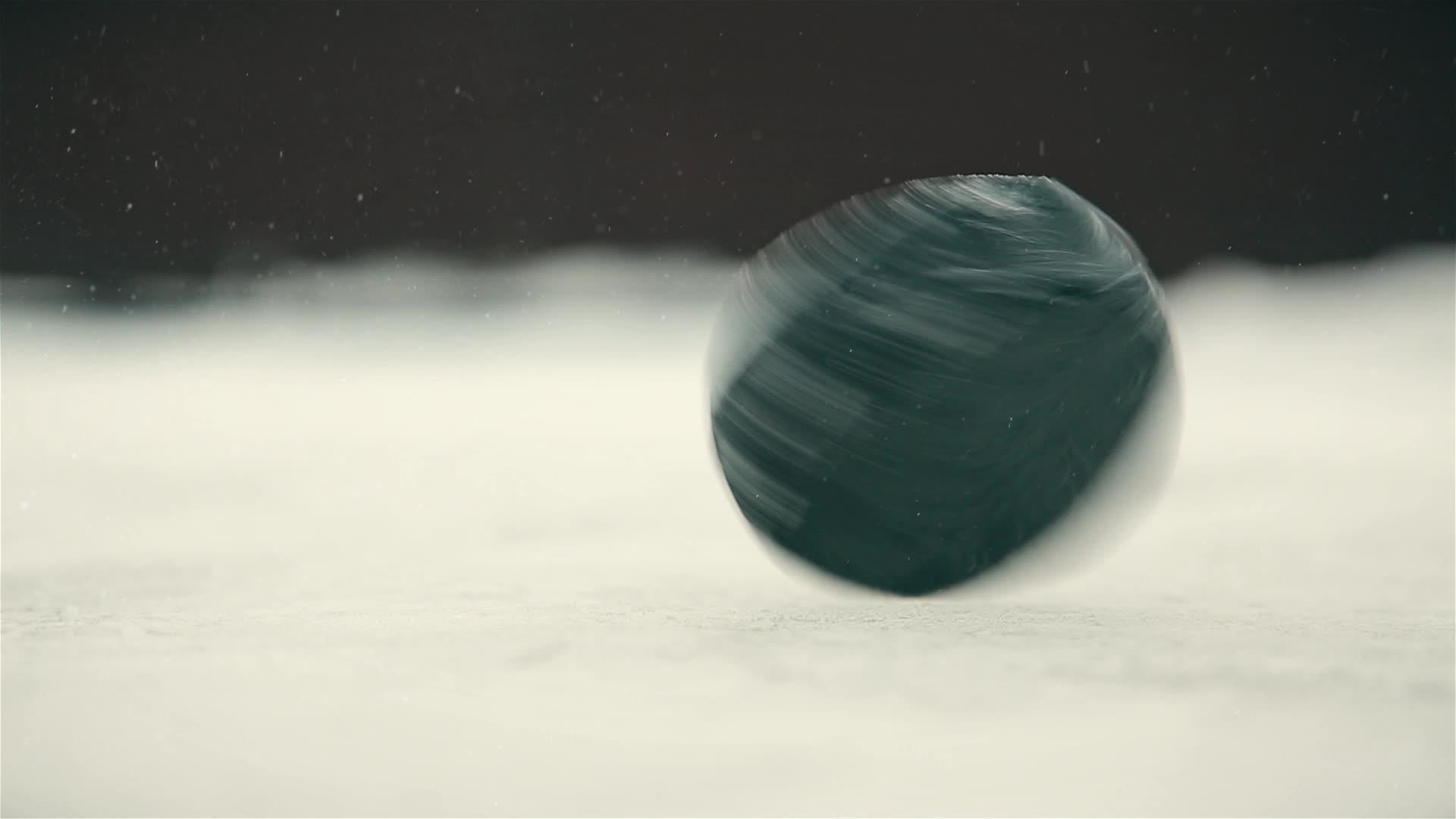 黑曲棍球在冰场上快速近距离旋转视频的预览图
