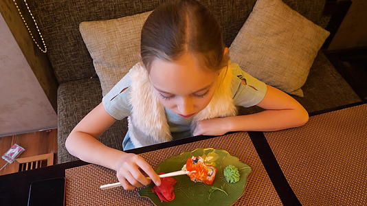 在日本寿司店女孩们吃寿司卷和筷子视频的预览图