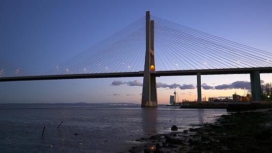日落时间在里奥特乔河附近RioTejo河边的桥视图视频的预览图