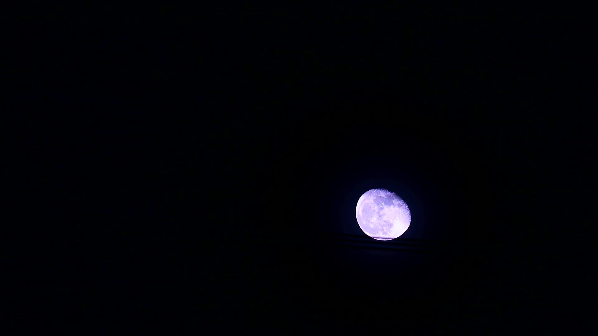 紫色的月亮在黑暗的夜空中通过电线移动视频的预览图