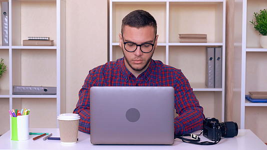 一在工作场所的男子穿着笔记本电脑穿着亮衬衫视频的预览图