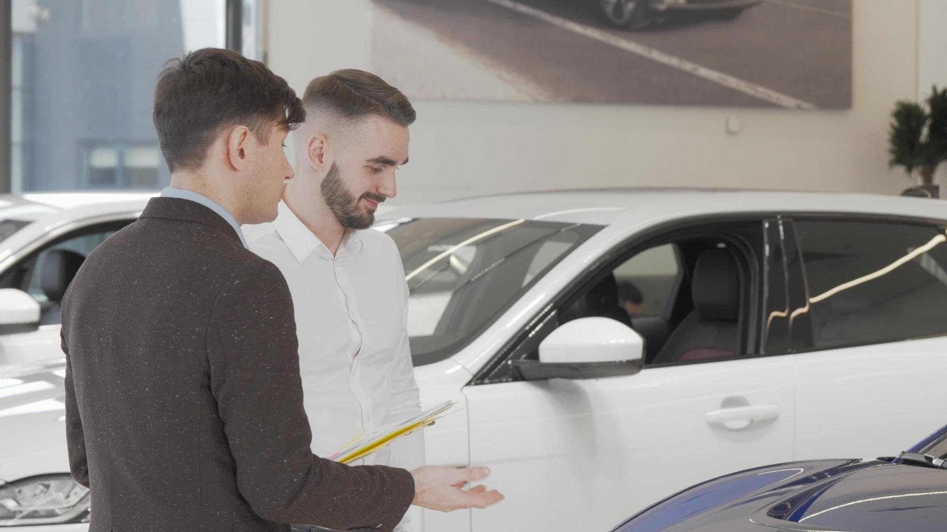 英俊的商人与汽车经销商的推销员交谈视频的预览图