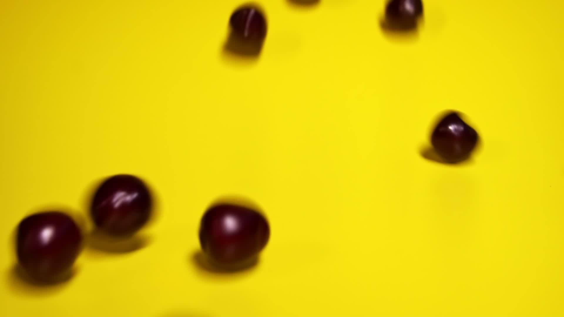 红色樱桃在黄色背景上反向滚动视频的预览图