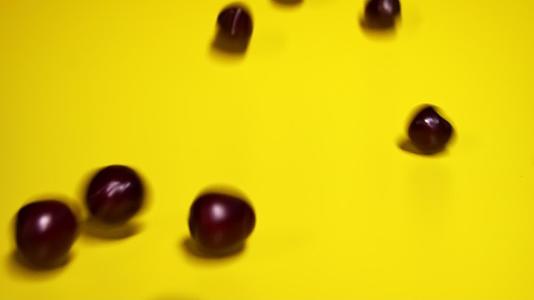 红色樱桃在黄色背景上反向滚动视频的预览图
