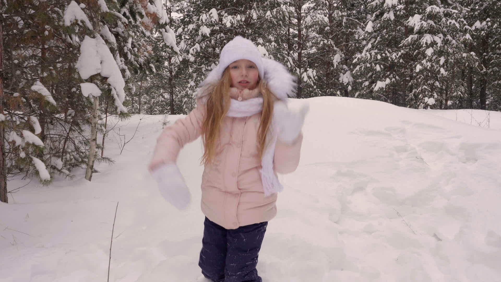 微笑的白人女孩在雪松树林里跳舞A跳下白雪视频的预览图