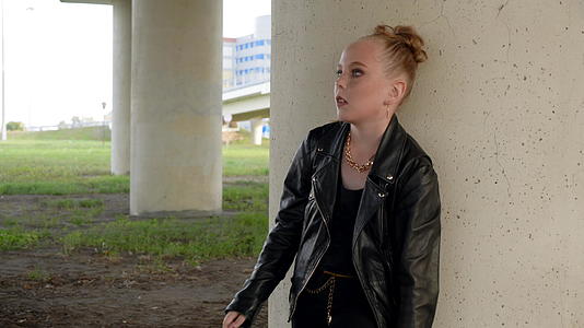 朋克女孩摇滚女孩站在桥桩下的黑色皮夹克视频的预览图