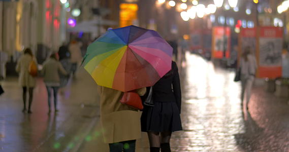 在雨夜城市在五颜六色的雨伞下行走视频的预览图