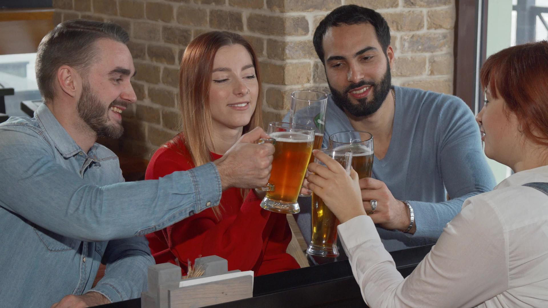快乐的朋友们在酒吧里喝着啤酒杯视频的预览图