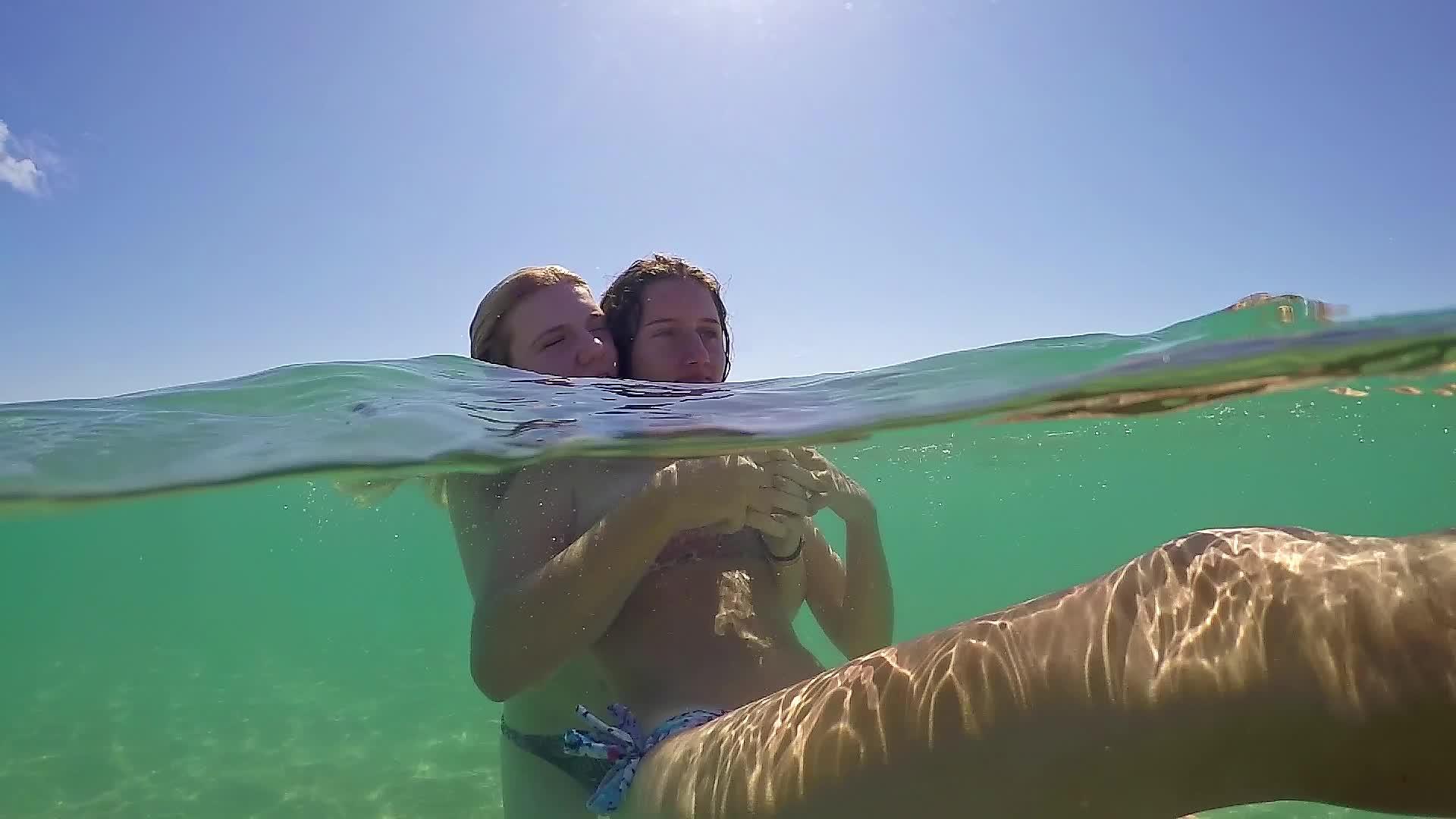 两个可爱的女孩在热带海滩的暑假里亲吻拥抱Gopro视频的预览图
