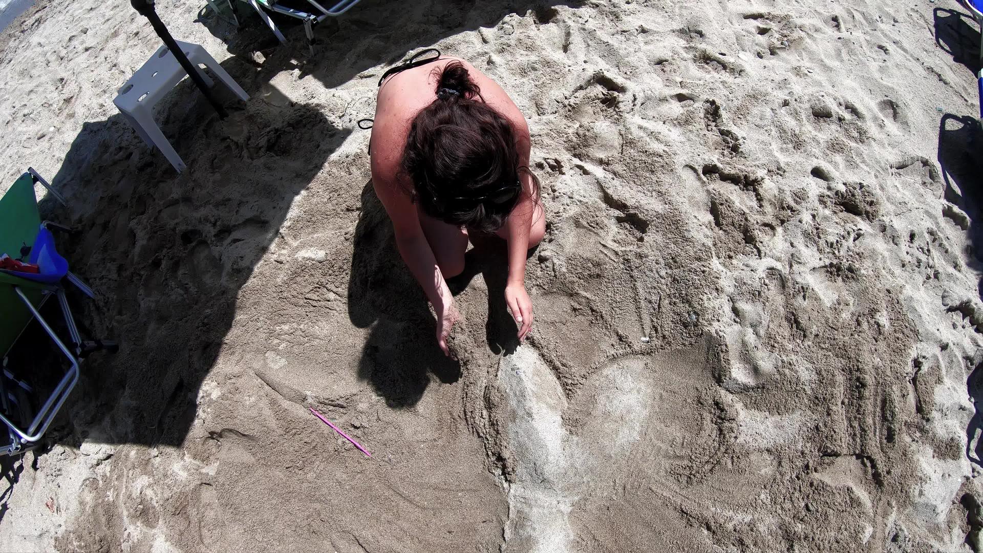 两位女性朋友在沙滩上做形状享受假期的慢动作视频的预览图