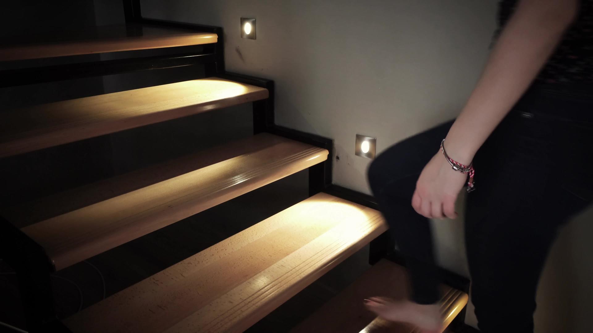 赤脚女人在木制家庭楼梯上开灯视频的预览图