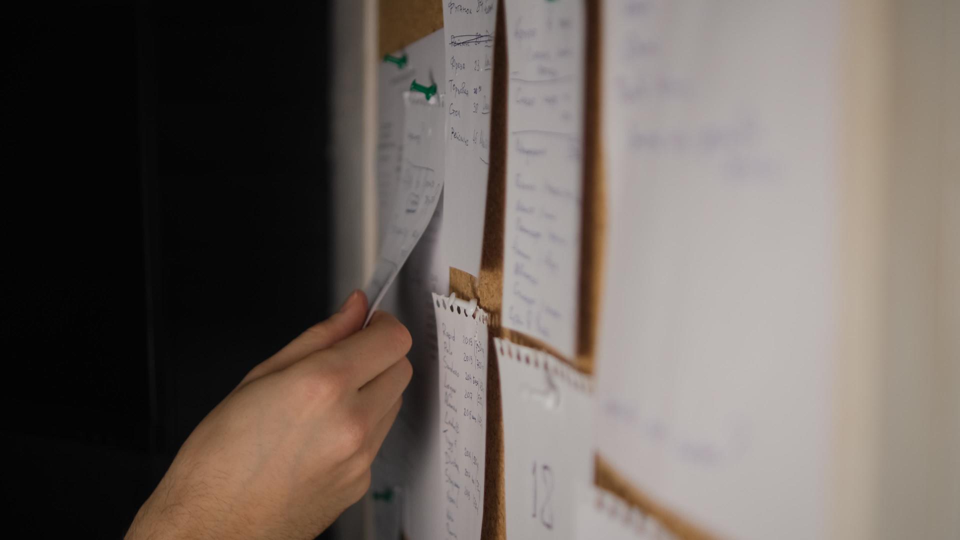 软木板上的便条纸笔记贴纸提醒男性选择性焦点的手移动视频的预览图