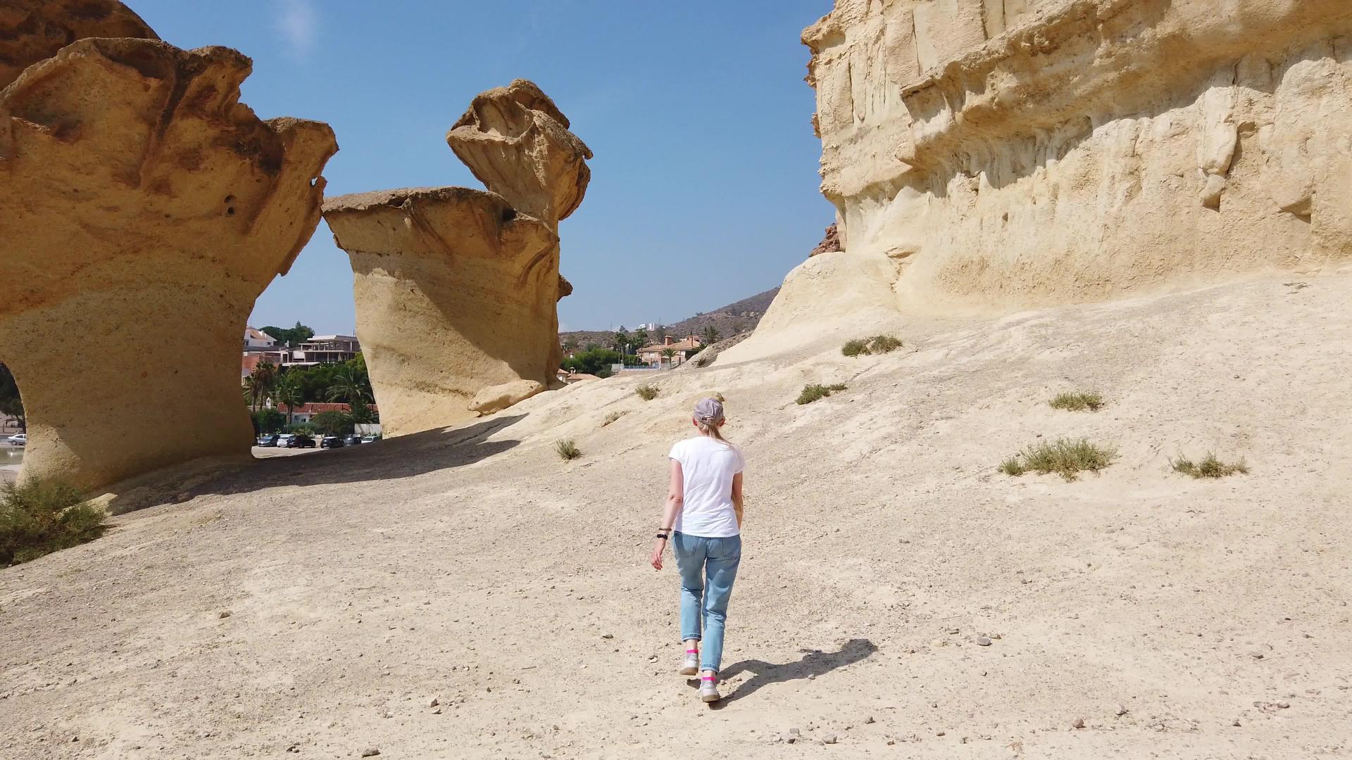 在沙漠中女孩走过沙漠沙漠靠近黄色的未来岩石视频的预览图