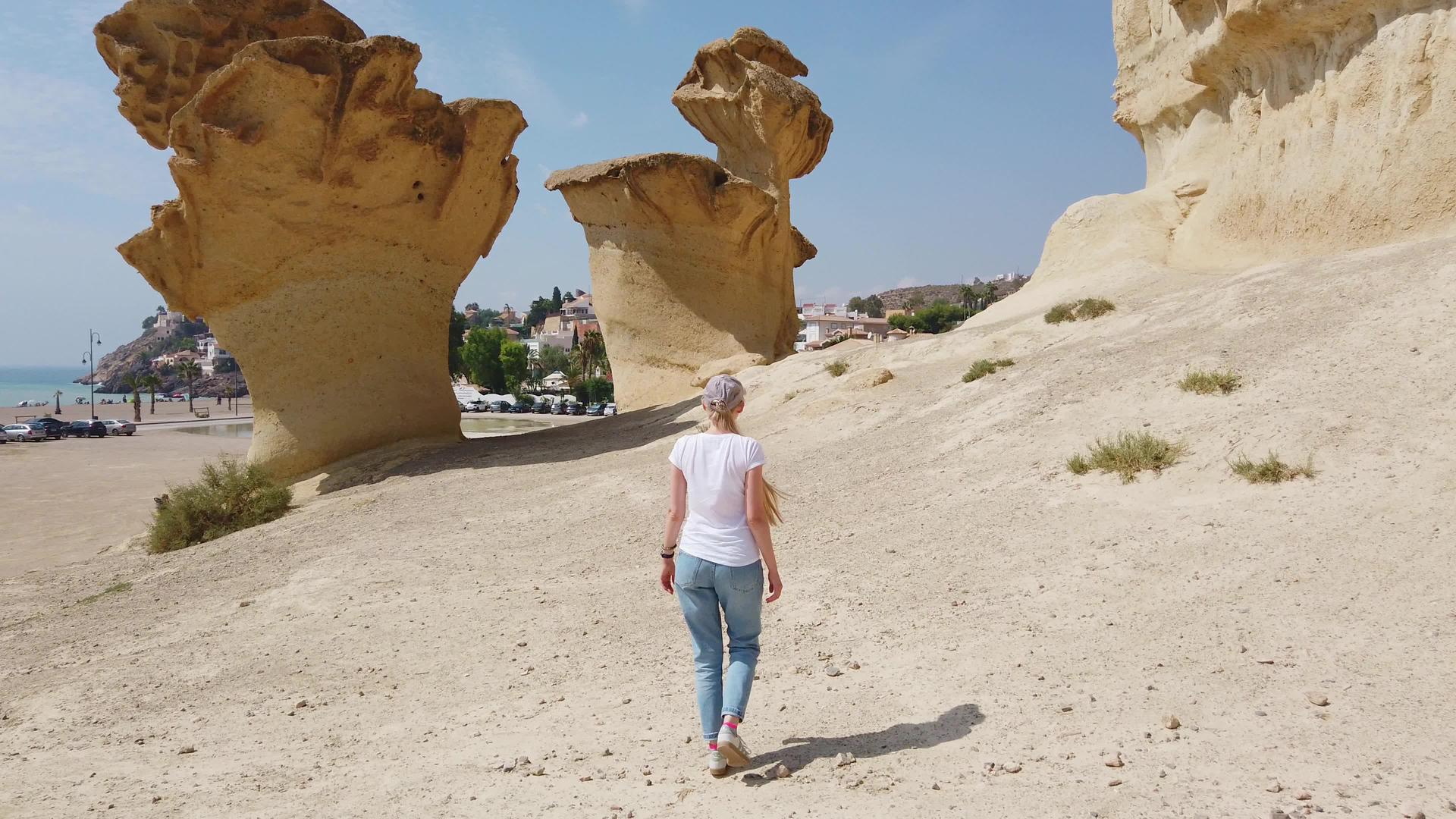 在沙漠中女孩走过沙漠沙漠靠近黄色的未来岩石视频的预览图
