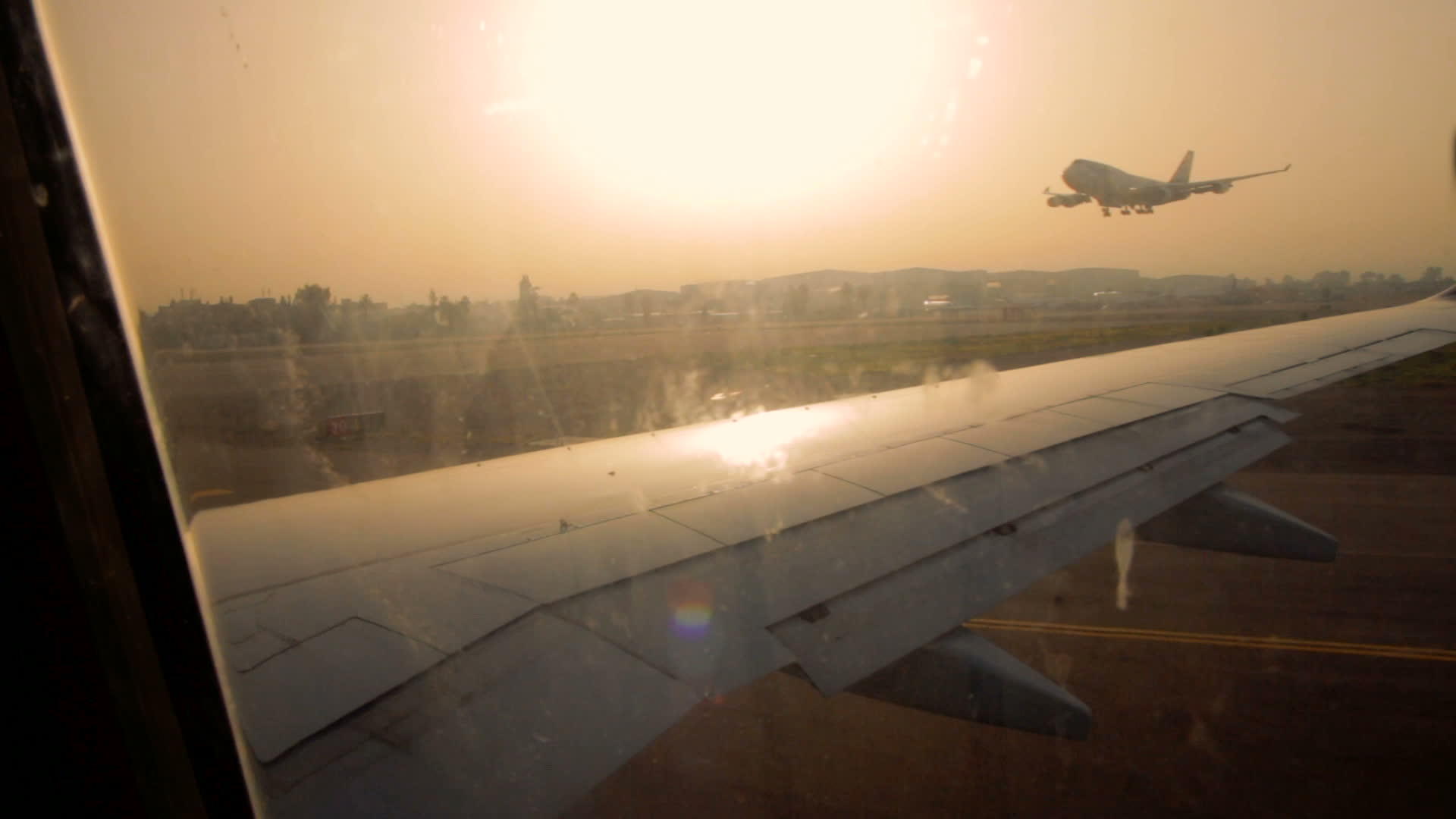 日出时班古里安机场跑道上的飞机机翼视频的预览图