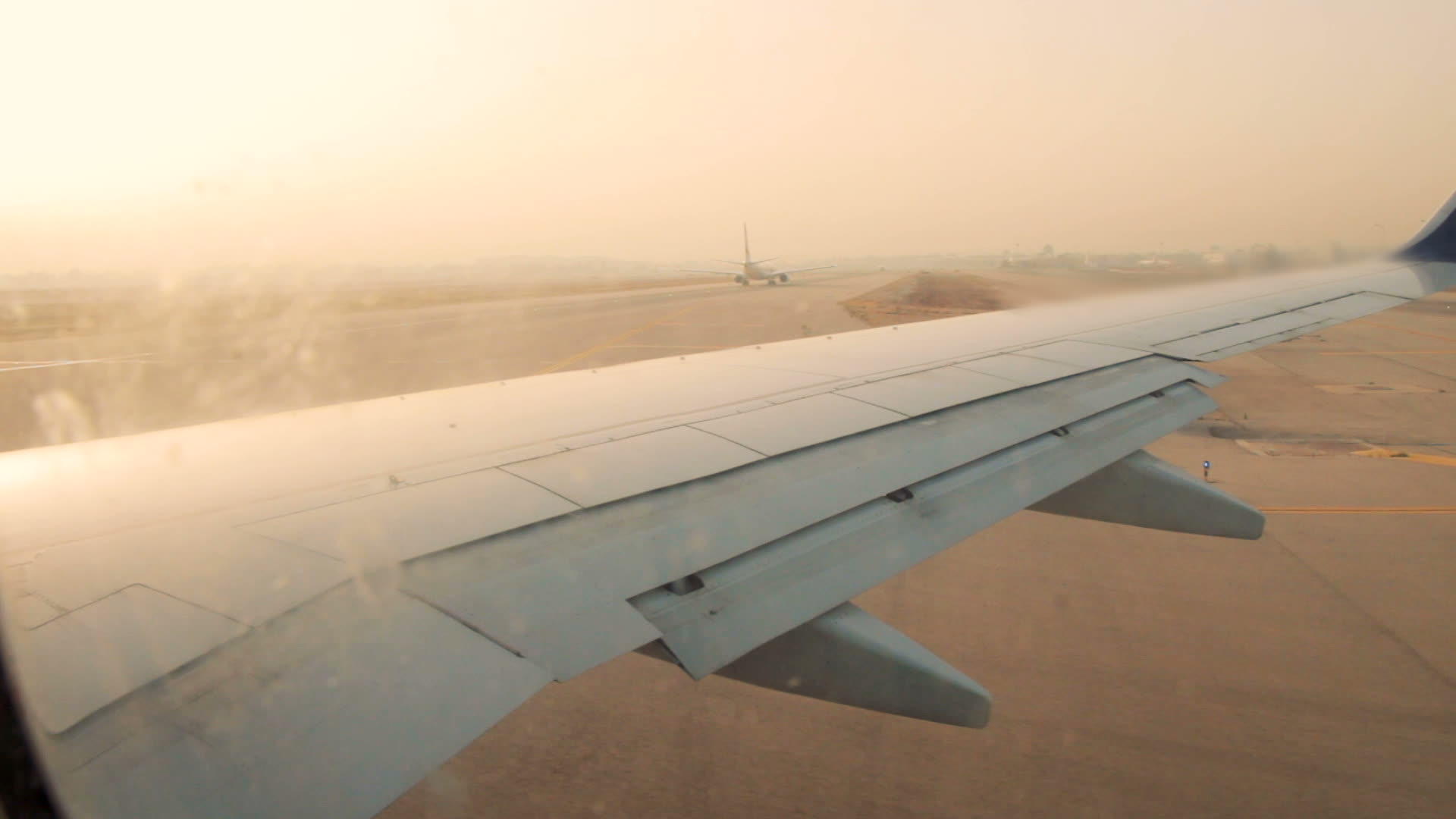 日出时班古里安机场跑道上的飞机机翼视频的预览图