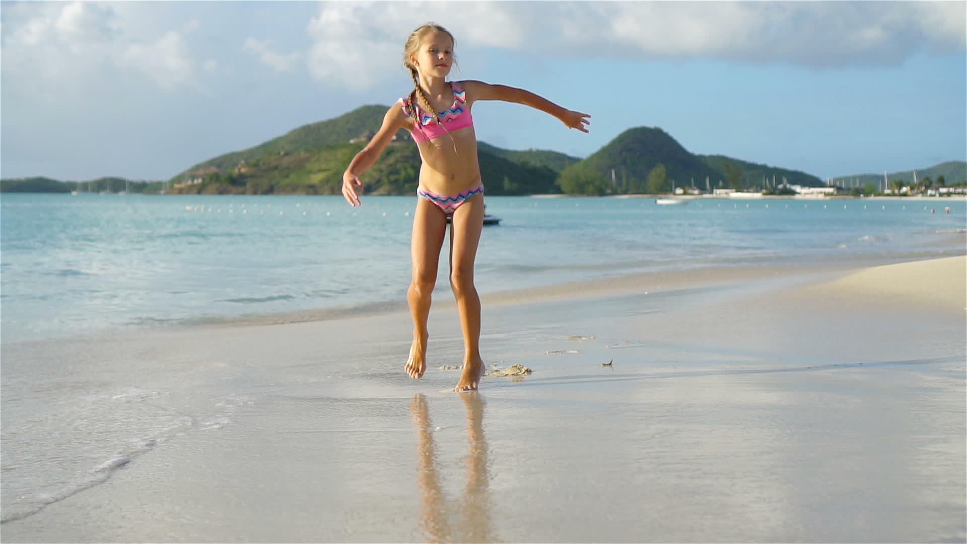 活跃的小女孩在白色沙滩上做了一个手推车视频的预览图