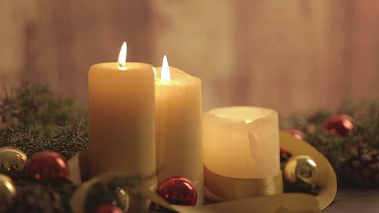 圣诞节的关闭充满了点燃蜡烛、松枝、天然松锥红和金盘子视频的预览图
