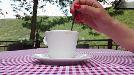 红指甲指甲的女人拿了一把勺子用一杯装满红色桌布的彩礼纸巾在上面视频的预览图