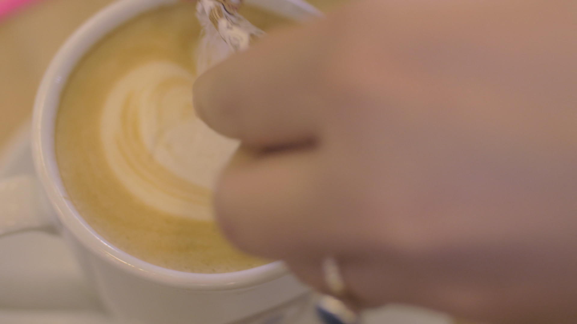 在咖啡杯里和泡沫女孩一起倒糖用勺子搅拌咖啡视频的预览图