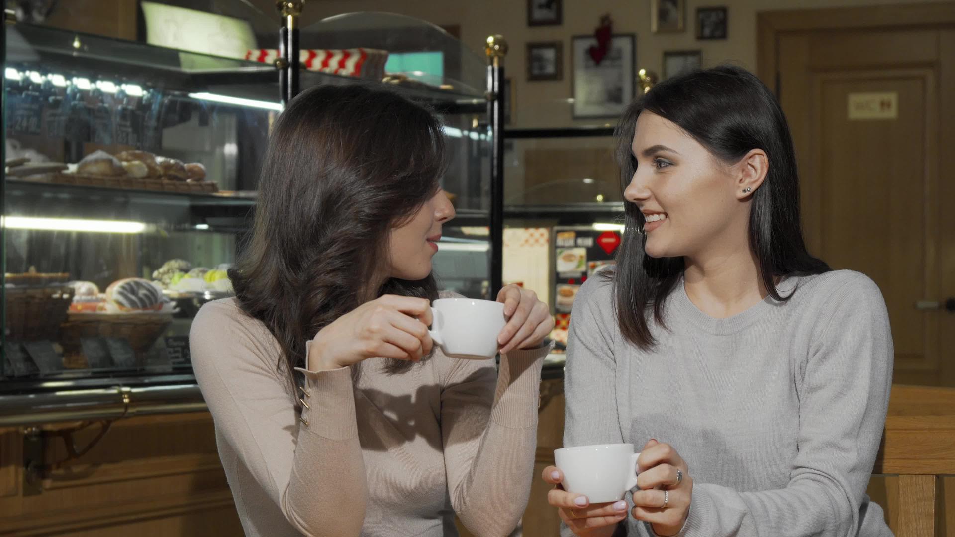 两个快乐的年轻女性朋友在咖啡店的相机上微笑视频的预览图