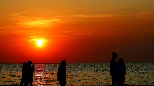 许多人拍摄海中日落的照片视频的预览图