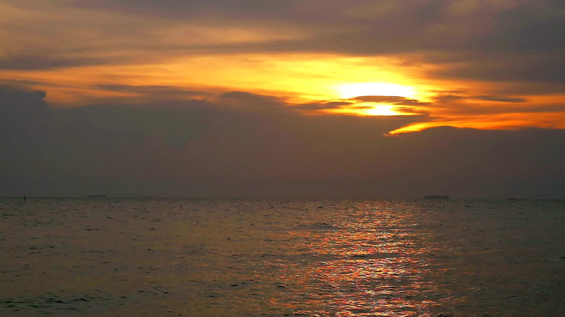 海水和天空中的乌云的日落反射视频的预览图