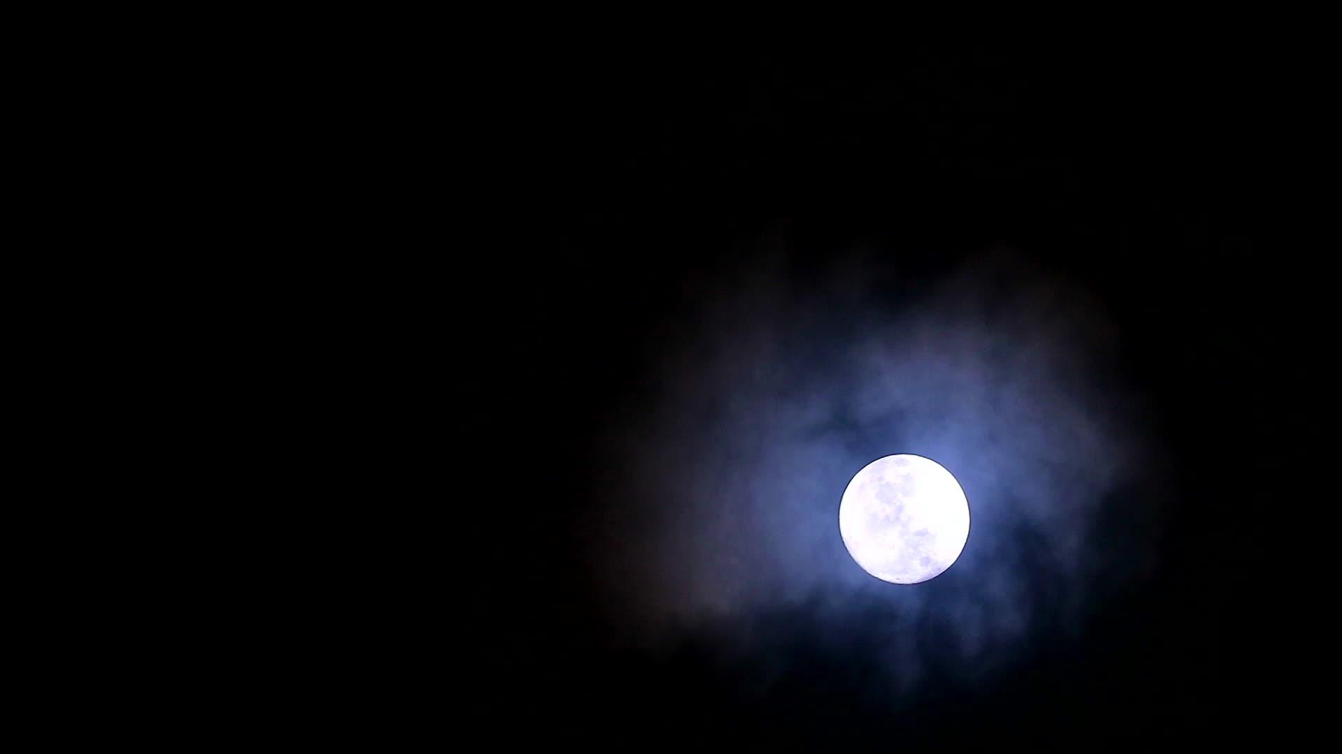 夜空中的黑月亮在寒冷的天空中回到柔软黑暗的云层视频的预览图