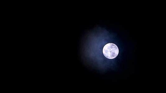 满月在夜晚漂浮在夜空和云中视频的预览图