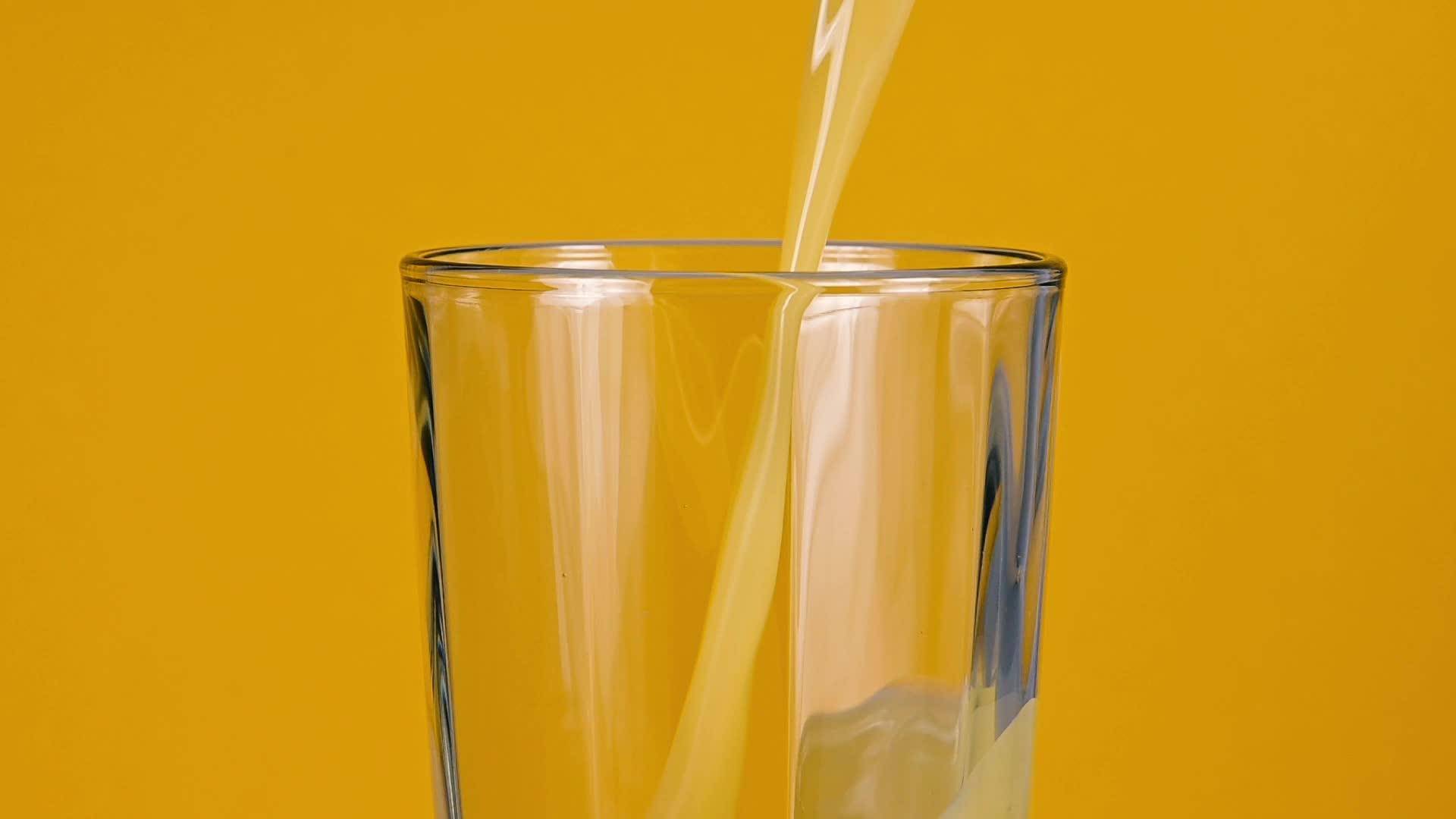 把橙汁倒在黄色的玻璃杯里视频的预览图