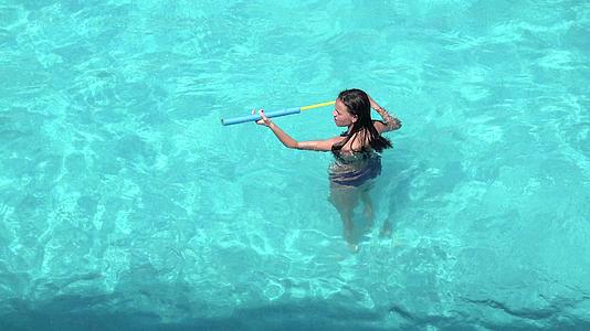在游泳池里玩水枪的女孩视频的预览图