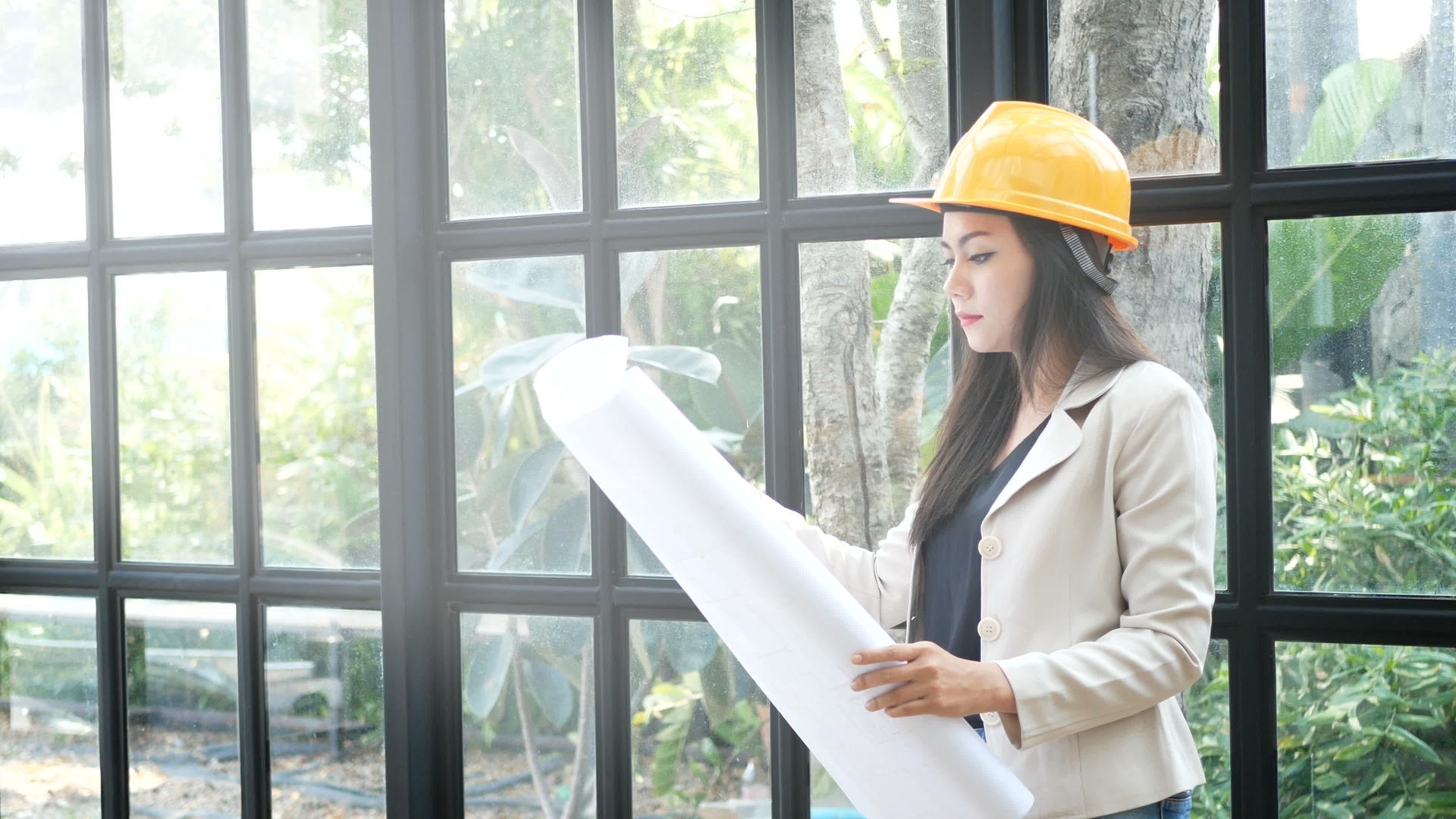 年轻的亚洲女建筑工程师戴着黄色的硬安全帽手里拿着建筑师视频的预览图
