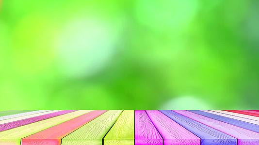 绿色模糊背景抽象多彩的叶子花树在花园和彩虹木块视频的预览图