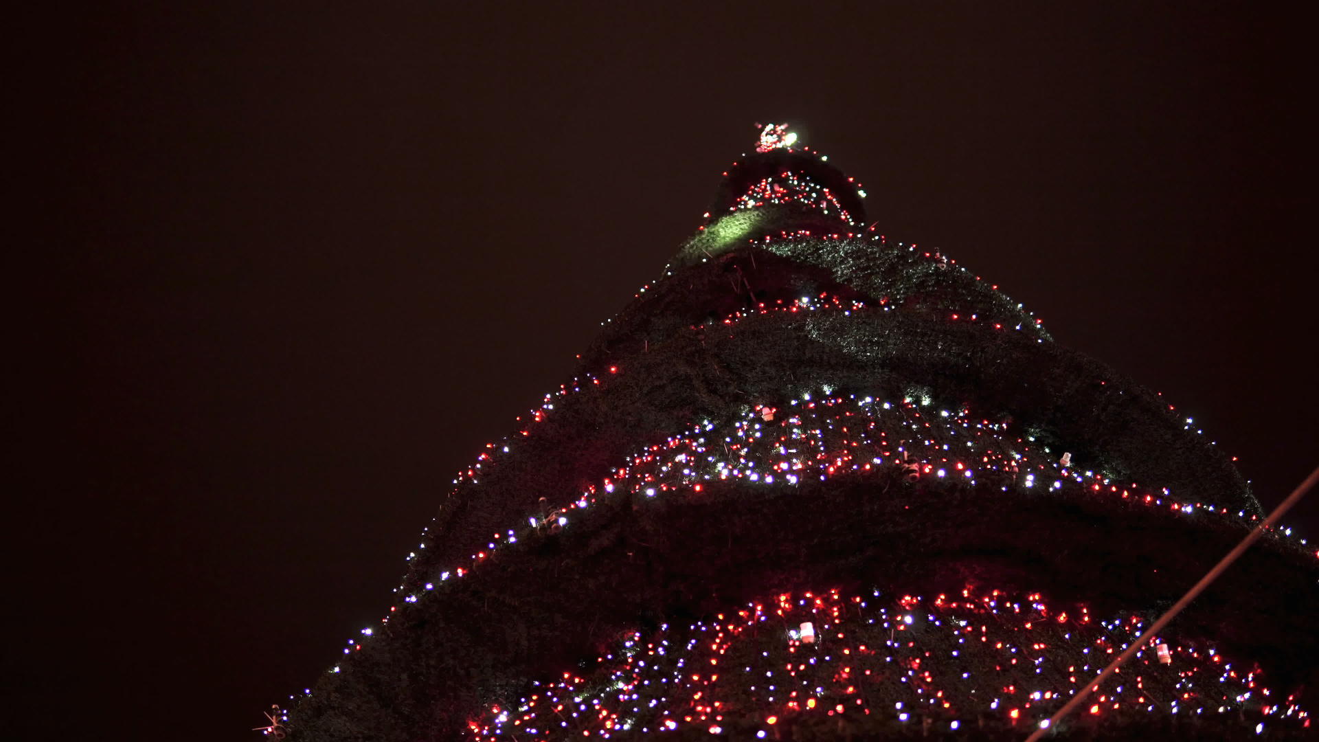 在圣诞节和新年树的夜晚黑暗背景的灯光照耀着新年树视频的预览图