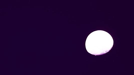 粉红色的月亮在夜顶的天空中移动太阳反射表面视频的预览图