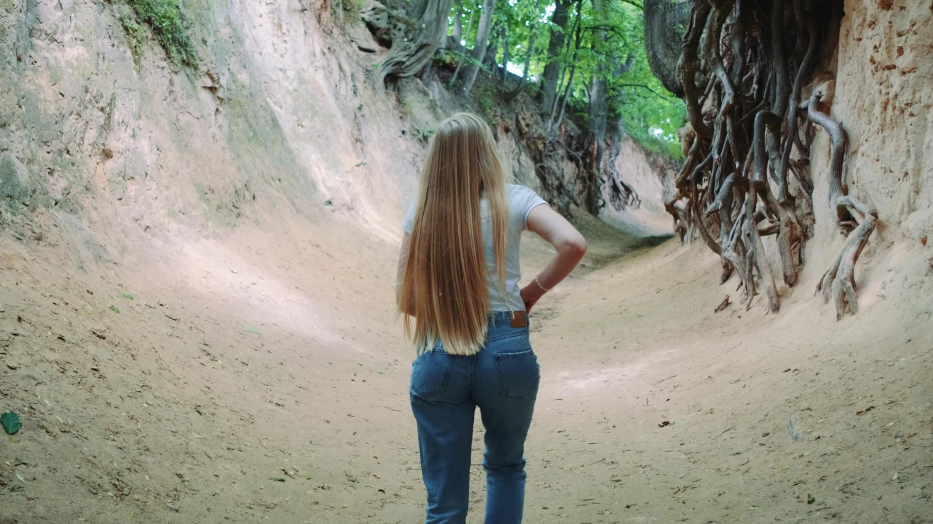 美丽的金发美女在自然峡谷中漫步视频的预览图