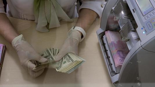 银行家手数美元机器数乌克兰格里夫亚纸币戴医用手套视频的预览图