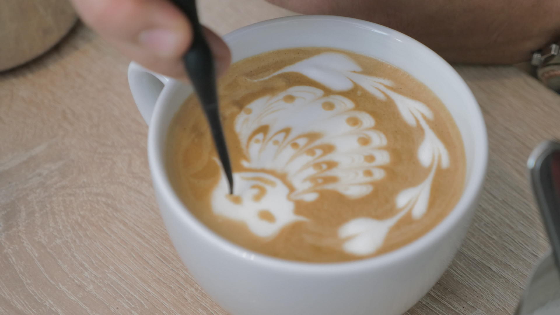 桌子上有一杯咖啡和一个泡沫咖啡杯男子提取泡沫模式视频的预览图