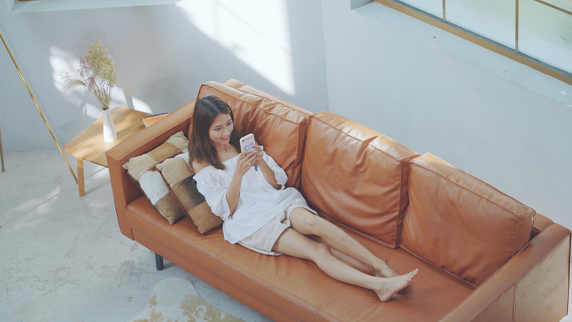 4K女生躺在沙发上使用手机视频的预览图